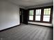 The bedroom boasts dark wood trim, three windows, neutral colored carpet, and an open closet at 509 Shelby St, Shelbyville, IN 46176
