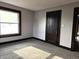 Bright bedroom with a window, neutral carpet, and dark wood trim accents the room at 509 Shelby St, Shelbyville, IN 46176