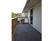 Here is an exterior shot showcasing a deck area with wooden railings and gray carpeting at 509 Shelby St, Shelbyville, IN 46176