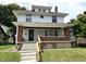 Charming two-story home with a welcoming front porch and brick accents on a well-maintained lawn at 509 Shelby St, Shelbyville, IN 46176