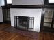 Detailed view of the fireplace with classic brick surround, black trim, and built-in shelving on either side at 509 Shelby St, Shelbyville, IN 46176
