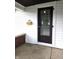 Charming front door with glass window and white siding for a warm welcome to the home at 509 Shelby St, Shelbyville, IN 46176