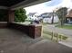 View of neighborhood from front porch, showcasing nearby homes and a brick support at 509 Shelby St, Shelbyville, IN 46176