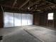 View of a two car garage with exposed rafters and a window providing natural light at 509 Shelby St, Shelbyville, IN 46176