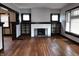 Inviting living room features a cozy fireplace, hardwood floors, and elegant dark trim, showcasing classic charm at 509 Shelby St, Shelbyville, IN 46176