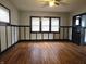 Spacious living room with beautiful hardwood floors, wainscoting details, and ample natural light from multiple windows at 509 Shelby St, Shelbyville, IN 46176