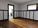 Inviting living room showcasing hardwood floors, wainscoting detail, and a glimpse into the adjacent, modern kitchen at 509 Shelby St, Shelbyville, IN 46176