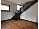 Hardwood staircase leads to the upper level, with a window providing natural light and a glimpse of the landing at 509 Shelby St, Shelbyville, IN 46176