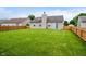 Spacious backyard with a large green lawn and wood fence at 5258 Brassie Dr, Indianapolis, IN 46235