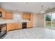 Eat-in kitchen features wooden cabinetry, ample counter space, and a sliding glass door that leads to the backyard at 5258 Brassie Dr, Indianapolis, IN 46235
