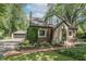 A brick home with lush greenery, a detached garage, and a long driveway are featured at 5315 Camden St, Indianapolis, IN 46227