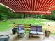 Cozy patio featuring outdoor seating under a red and white striped awning, overlooking a lush backyard at 5654 Paradise Dr, Martinsville, IN 46151