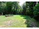 Expansive backyard features a lush lawn and mature trees, perfect for outdoor activities at 5654 Paradise Dr, Martinsville, IN 46151