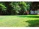 Expansive green backyard with mature trees and a glimpse of the home's architecture at 5654 Paradise Dr, Martinsville, IN 46151