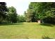 Spacious backyard with mature trees and a small shed, offering a serene and private outdoor space at 5654 Paradise Dr, Martinsville, IN 46151