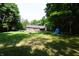 Large backyard featuring mature trees, a firepit, and a covered woodpile at 5654 Paradise Dr, Martinsville, IN 46151