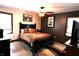 Comfortable bedroom with a ceiling fan, dark wood furnishings, and natural light from the windows at 5654 Paradise Dr, Martinsville, IN 46151