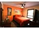 Bedroom featuring an orange accent wall, ceiling fan, and natural light from the windows at 5654 Paradise Dr, Martinsville, IN 46151