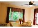 Dining area featuring a wooden table set, natural light from a large window, and decorative curtains at 5654 Paradise Dr, Martinsville, IN 46151