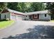 Charming home featuring stone accents, red siding, attached two-car garage, and a circular driveway at 5654 Paradise Dr, Martinsville, IN 46151