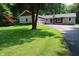 Landscaped front lawn with a mature tree leading up to a charming home with stone and red siding at 5654 Paradise Dr, Martinsville, IN 46151