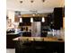 A kitchen with stainless steel appliances, pendant lights, and dark cabinets with stone countertops at 5654 Paradise Dr, Martinsville, IN 46151