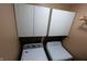 Bright laundry area with overhead storage cabinets and modern side-by-side washer and dryer units at 5654 Paradise Dr, Martinsville, IN 46151