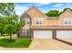 Attached garage and driveway of home; a beautiful landscaped tree in yard at 5677 Brownstone Dr # 5677, Indianapolis, IN 46220