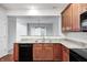 Modern kitchen with granite countertops, stainless sink and dark wooden cabinets at 5677 Brownstone Dr # 5677, Indianapolis, IN 46220