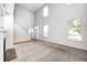 Open-concept living room with fireplace, staircase, and large windows, filling the space with natural light at 5677 Brownstone Dr # 5677, Indianapolis, IN 46220