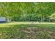 Expansive backyard with a fire pit and seating area surrounded by mature trees at 5710 W 650 N, Thorntown, IN 46071