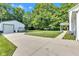 View of a detached garage with a basketball hoop, concrete driveway, and well-manicured lawn at 5710 W 650 N, Thorntown, IN 46071