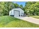 Detached garage with roll-up doors, concrete pad, and well-kept landscaping in the background at 5710 W 650 N, Thorntown, IN 46071