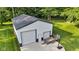 An overhead view of a metal outbuilding featuring two garage doors and a basketball hoop on a well-maintained lawn at 5710 W 650 N, Thorntown, IN 46071
