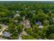 An aerial view of the neighborhood featuring many homes nestled among mature trees and green landscapes at 5805 Forest Ln, Indianapolis, IN 46220
