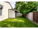 An open backyard featuring a shed, partial fencing, and healthy green grass at 5805 Forest Ln, Indianapolis, IN 46220