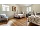 Charming bedroom featuring two twin beds, wood floors and natural light from two windows at 5805 Forest Ln, Indianapolis, IN 46220