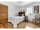 Cozy bedroom with hardwood floors, headboard detail, and a sunny window view at 5805 Forest Ln, Indianapolis, IN 46220