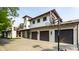Spacious stone driveway and three-car garage with a basketball hoop next to lush trees at 5805 Forest Ln, Indianapolis, IN 46220
