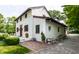 The home's side yard featuring an alternate entryway, manicured hedges, and brick patio at 5805 Forest Ln, Indianapolis, IN 46220
