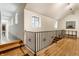 Bright hallway with hardwood floors and black metal railing near stairs at 5805 Forest Ln, Indianapolis, IN 46220