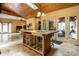 A kitchen with wooden floors, stone floors, wood paneled ceilings, and an island with stainless steel appliances at 5805 Forest Ln, Indianapolis, IN 46220