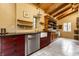 A kitchen features custom cabinetry, stainless steel appliances, and stone floors with wood paneled ceilings at 5805 Forest Ln, Indianapolis, IN 46220