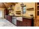 A kitchen featuring stainless steel appliances, custom cabinetry, stone floors, and wood paneled ceilings at 5805 Forest Ln, Indianapolis, IN 46220