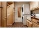 Functional laundry room with stackable washer/dryer, ample cabinet space, and hexagon tiled floors at 5805 Forest Ln, Indianapolis, IN 46220