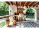 Charming outdoor kitchen under a covered patio with a grill and wood burning pizza oven at 5805 Forest Ln, Indianapolis, IN 46220