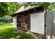 Large backyard shed with wooden doors, new roof, and adjacent basketball court at 5805 Forest Ln, Indianapolis, IN 46220