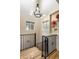 Staircase with wrought iron railing, wood steps, and a decorative chandelier, offering an elegant touch at 5805 Forest Ln, Indianapolis, IN 46220