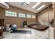 Relaxing sunroom featuring a hot tub, skylights, neutral-toned walls, and ample space for exercise equipment at 5805 Forest Ln, Indianapolis, IN 46220