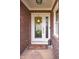 Front door with sidelight, yellow flower wreath, welcome mat, and brick exterior at 6483 Royal Oakland Dr, Indianapolis, IN 46236
